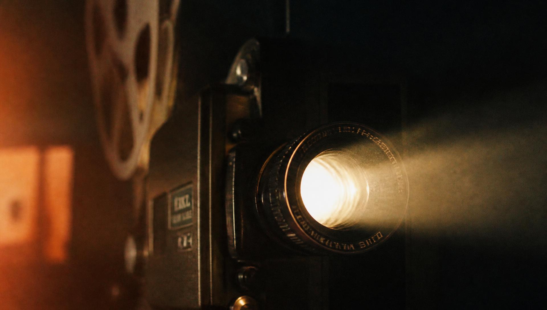 Vintage film projector lens glowing in a dark room